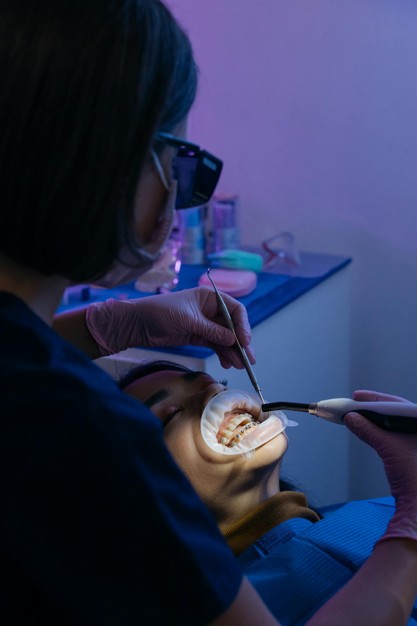 A dentist performing a dental procedure on a patient in a modern clinic setting.