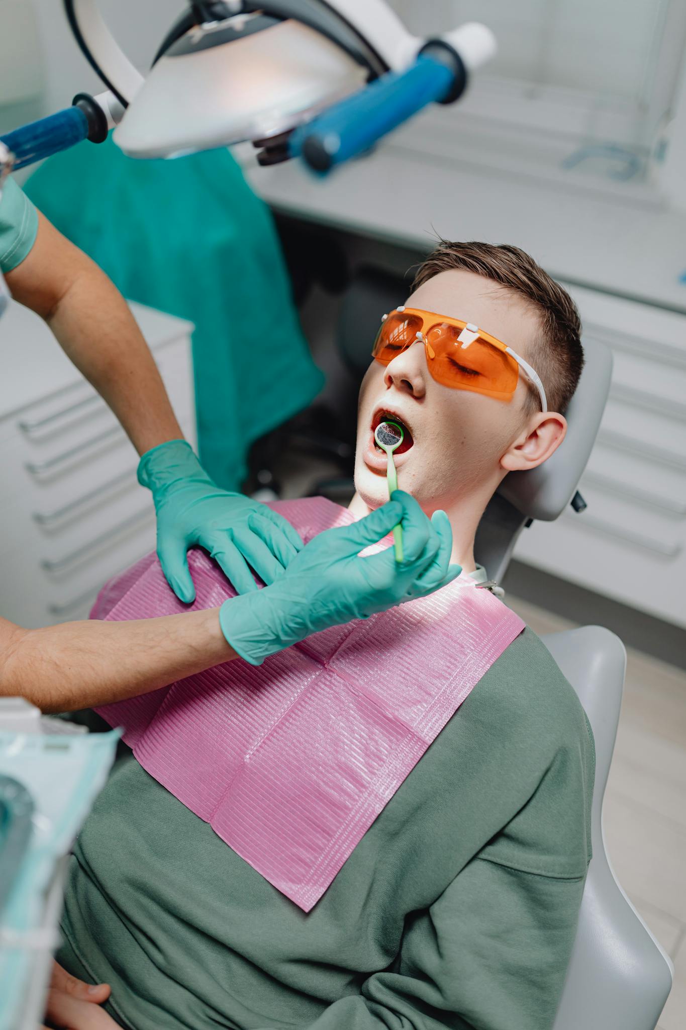 A young adult receives dental treatment at a modern clinic, showcasing oral hygiene practices.