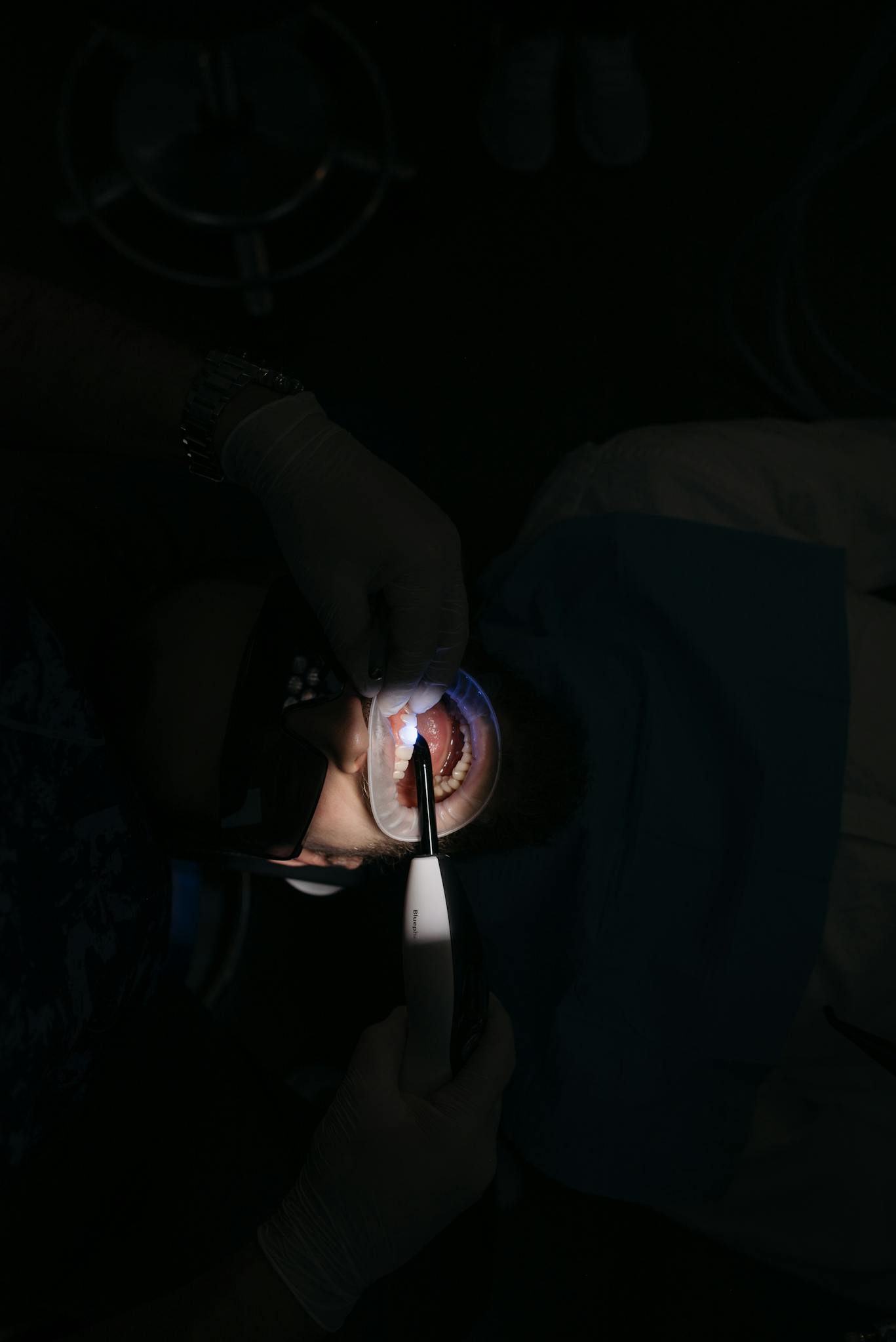 Dentist performing a dental procedure using medical instruments on a patient in a clinic.